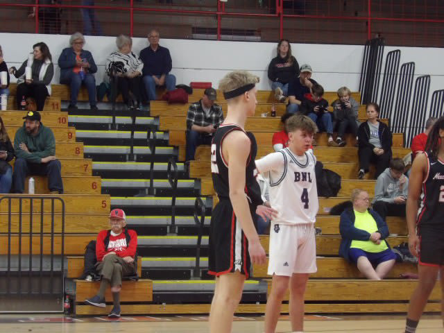Basketball players on court with crowd in background