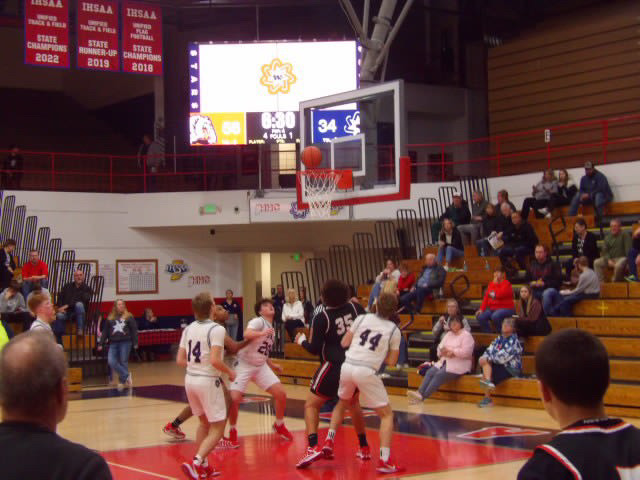 Basketball player shooting near the hoop with scoreboard