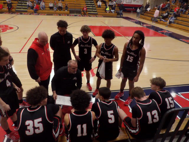 Basketball team in a huddle with their coach